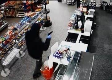David Parkin brandishes a gun during the robbery on February 14.