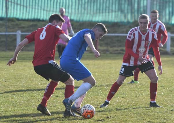 Seaham Red Star (blue) keep the ball under pressure from Sunderland RCA in their recent clash. Picture by Kevin Brady