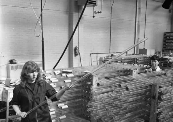 A 1966 photograph showing workers with glass tubes at Pyrex.