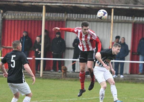 Sunderland RCA's Stephen Callen (red/white) rises to get in a header against Newcastle Benfield on Saturday. Picture by Kevin Brady