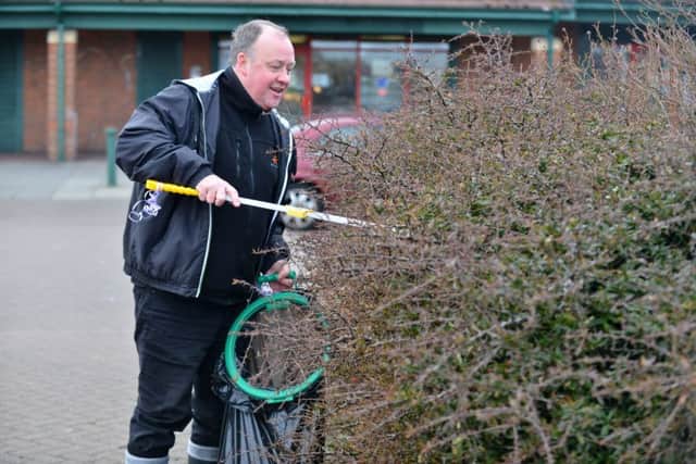 Councillor Stephen Foster helps remove litter from bushes in Town End Farm.