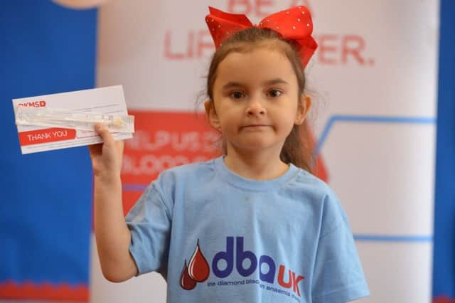 Chloe Gray with one of the DKMS swab kits used to find stem cell donors.