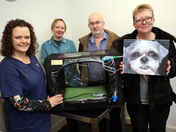 Vet Jane Thompson, support staff Liz Dewart, Jim Fagan and Dorothy Fagan, holding a picture of Max