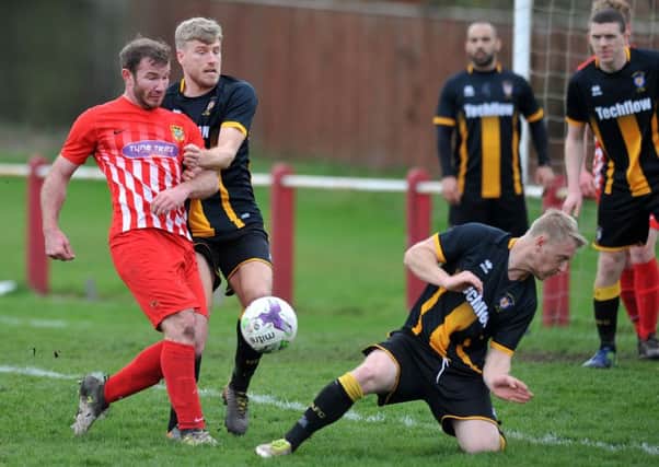 Northern League action as Ryhope CW's Mickey Rae (red) keeps the ball under pressure against Morpeth Town on Saturday. Picture by Tim Richardson