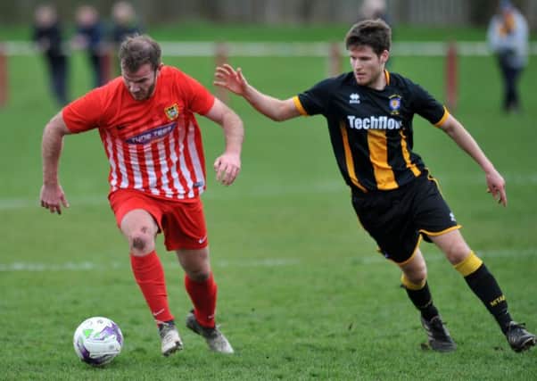 Ryhope CW striker Mickey Rae (red) keeps possession against Morpeth Town last week. Picture by Tim Richardson