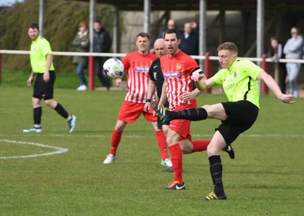 Bishop Auckland's Darren Richardson (yellow) clears under pressure from Ryhope CW skipper Chris Trewick. Picture by Kevin Brady