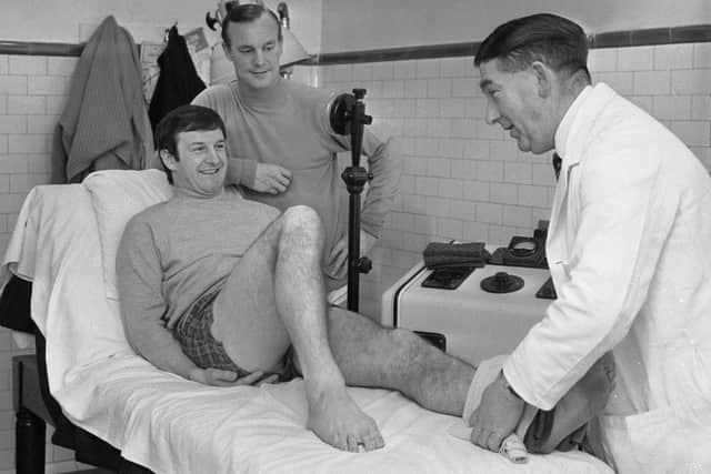 George Mulhall receives treatment for an ankle injury from physiotherapist John Watters in January 1968, as Gordon Harris looks on