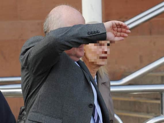 John Briers covers his face outside Newcastle Crown Court.