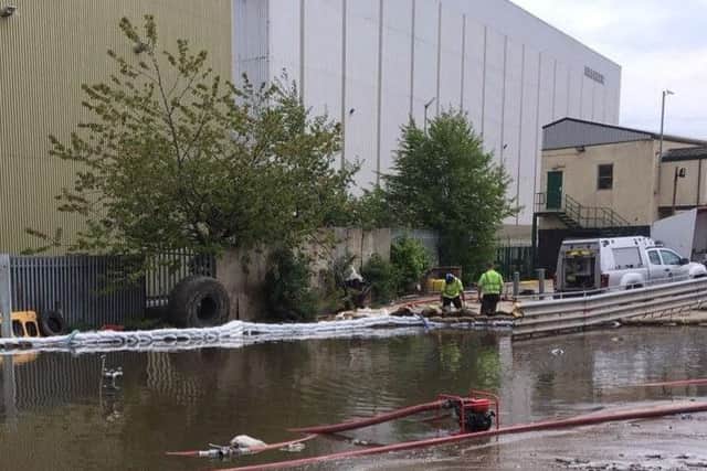 Firefighters and Environment Agency staff have built a sandbag wall to prevent run-off water from the Alex Smiles fire affecting other businesses. Pic: Environment Agency.