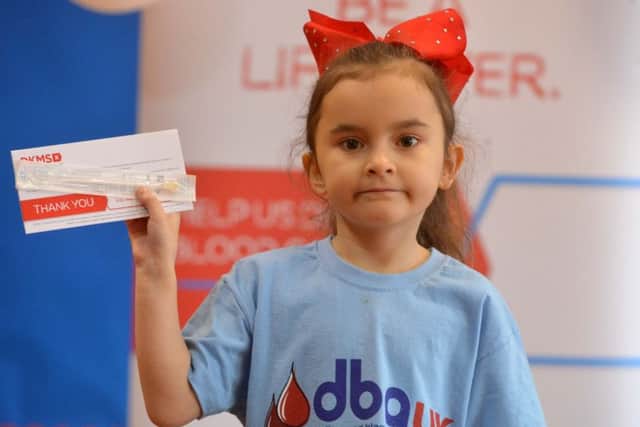Chloe Gray with one of the DKMS swab kits used to find stem cell donors.